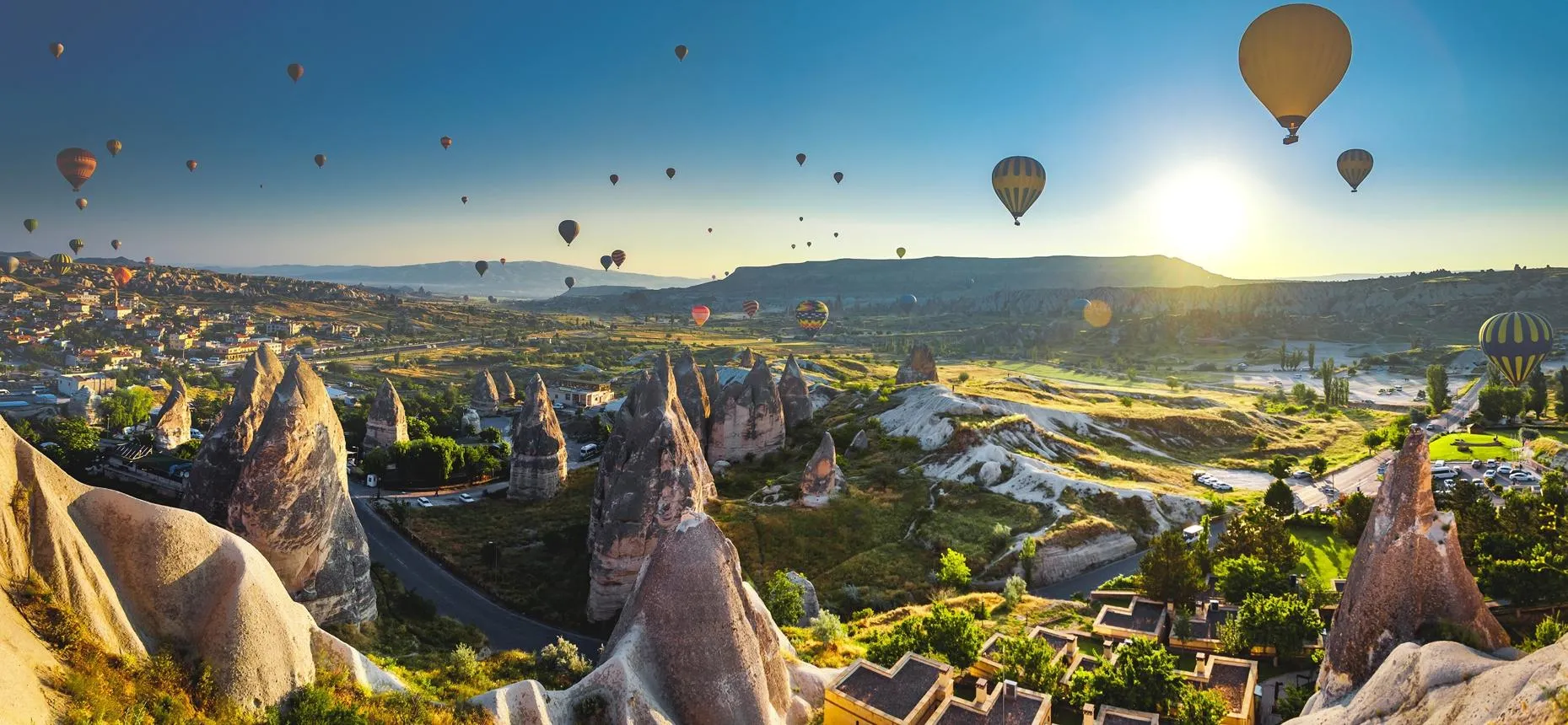 Hot air balloons rising over the fairy chimneys of Göreme at sunrise