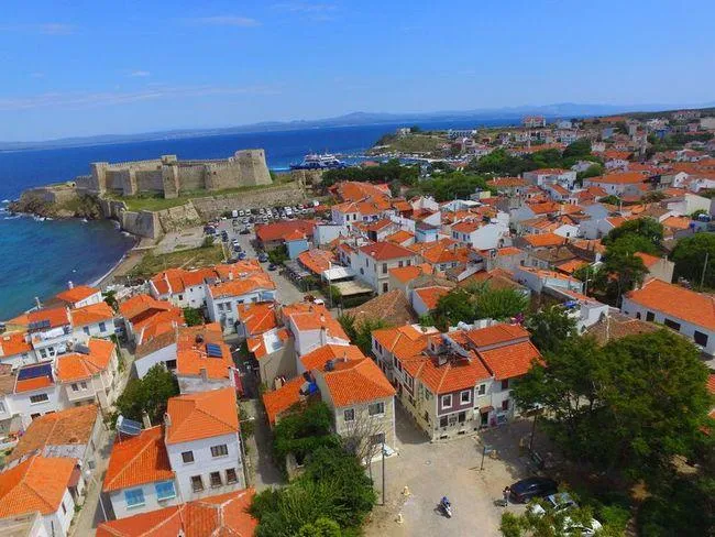 Red roofs of Bozcaada town and its castle above the harbour