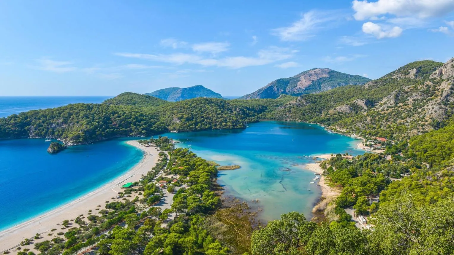 The Blue Lagoon of Ölüdeniz and its long sand spit below green mountains