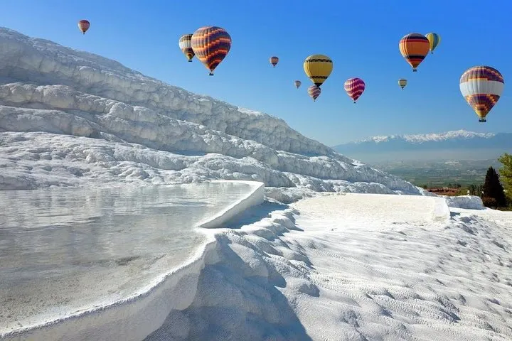 Hot air balloons above the white terraces of Pamukkale