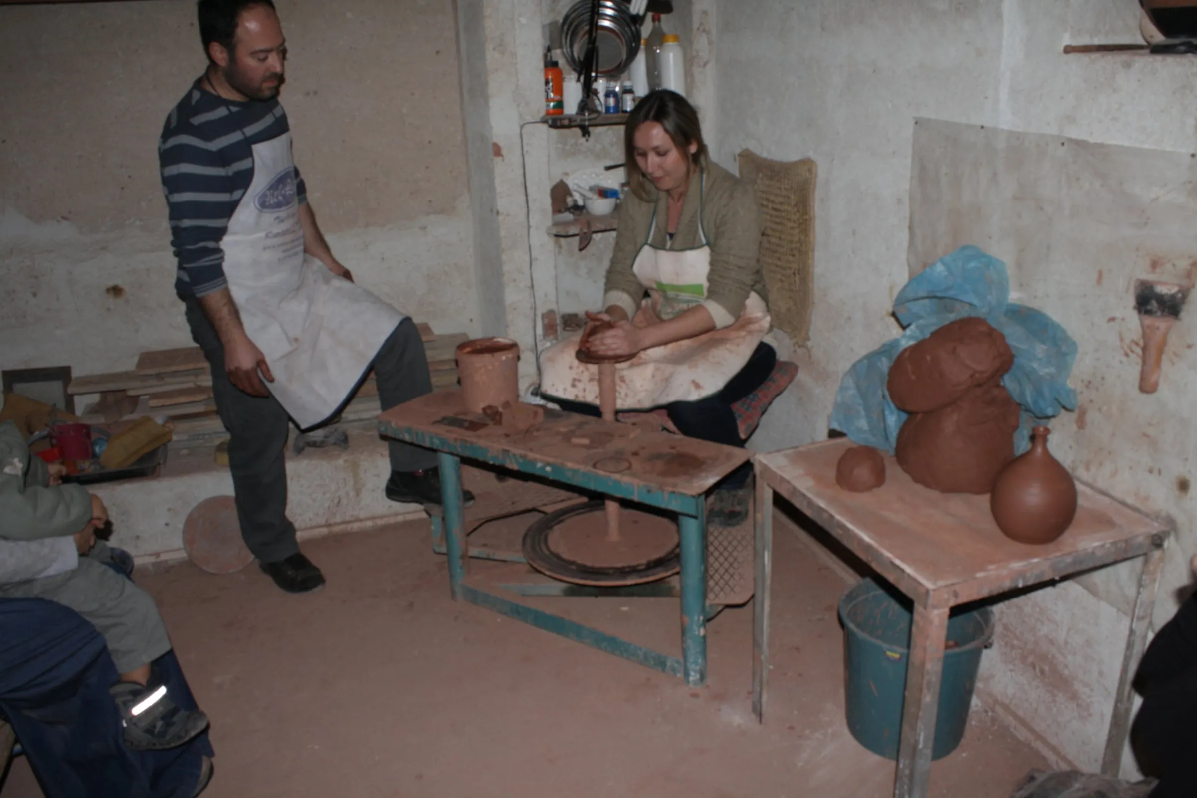 A potter shaping clay at the wheel in a village workshop